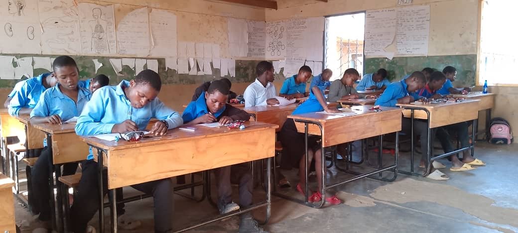 Children at their desks in a Kasungu classroom, drawing during the activity